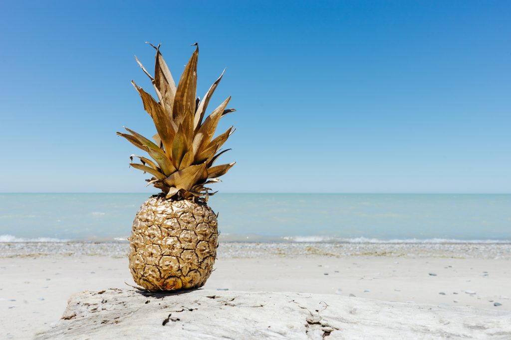 goldene Ananas am Strand als Symbol für Pinatex Fasern